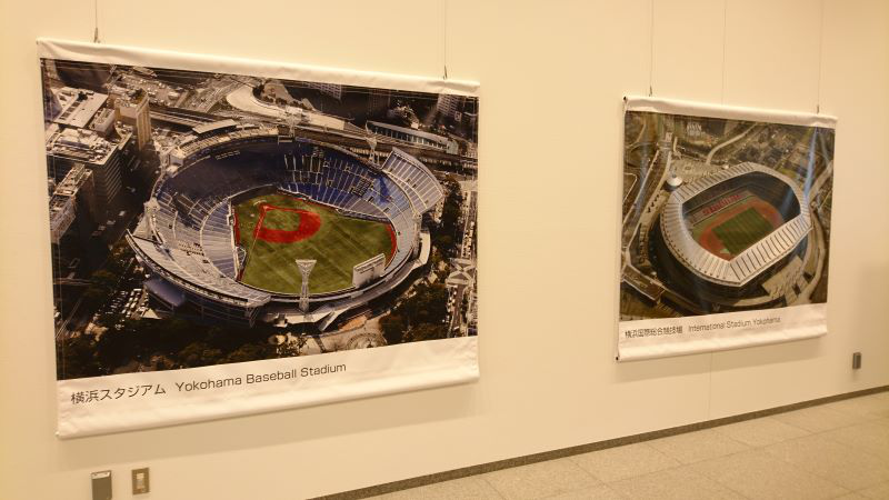 横浜市役所に掲げられた横浜スタジアムと、日産スタジアムの写真。