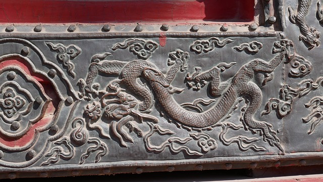 中国の古い建物の門に掘られた龍の絵の写真。