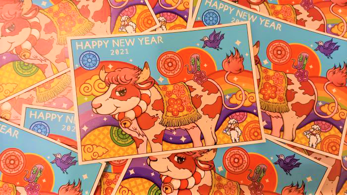 2021年丑年の、赤いホルスタイン牛とアマビエと羊の描かれた「クリエイターズ年賀状」がバラバラにたくさん並べられた写真。